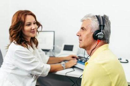 Audiologist conducts hearing screening on patient
